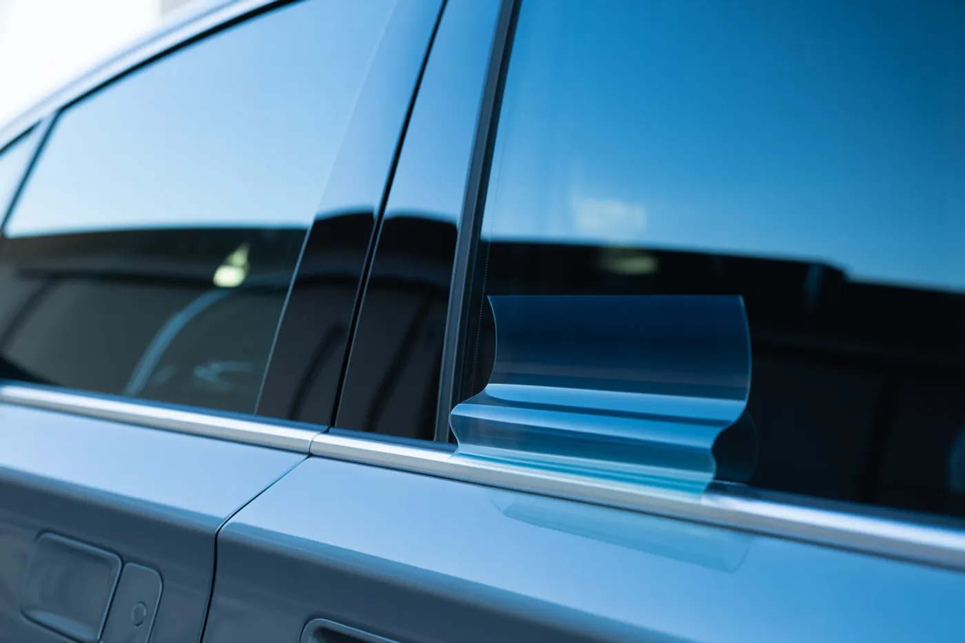 Dark ceramic tint film being applied to a car window