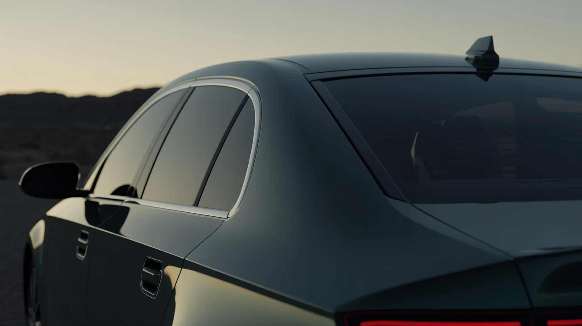 A car's windshield, side windows, quarter glass and rear glass at dusk in the Arizona desert